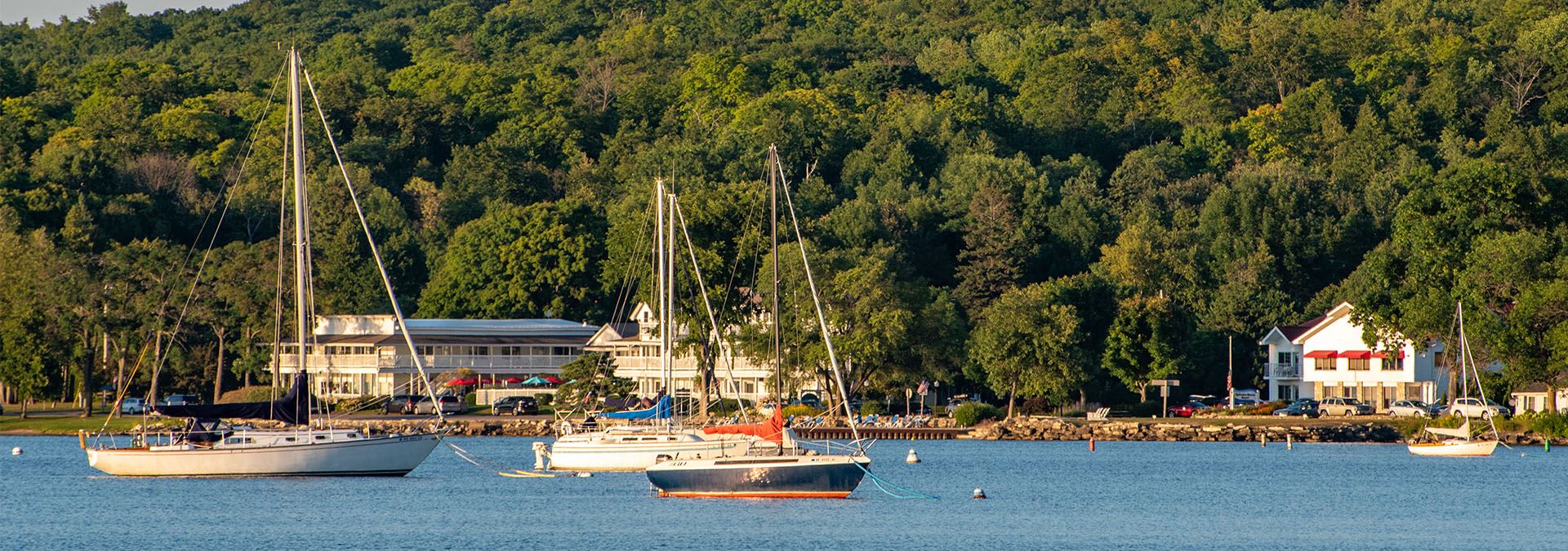 Sailboats out on the lake with the shoreline in the distance.