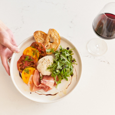 Beautiful plate of food next to a glass of red wine.